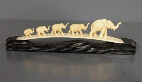 Decorative Elephant Figurines on Wooden Stand Description: Decorative Elephant Figurines on Wooden Stand, plastic elephants following in a row, arch shape on a wooden stand