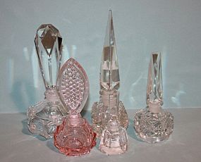 Five Glass Perfume Bottles Description: Five Glass Perfume Bottles; four clear glass and one peach color glass. One clear glass bottle has an edge with an image of the Eiffel Tower. 4 1/2" h. to 9 1/2" h.