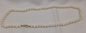 One Even Single Strand Pearl Necklace 16.0" Choker Length One even single strand pearl necklace 16.0" choker length, knotted with a 14 kt yellow gold clasp containing 67 cultured pearls, 5.1mm in size to 5.4mm in size. The pearls are white in co