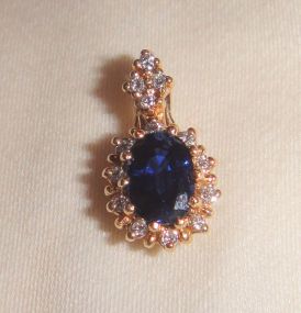 One stamped 14KT yellow gold lady's cast sapphire and diamond pendant One stamped 14KT yellow gold lady's cast sapphire and diamond pendant with a bright polish finish. Containing: One prong set oval standard brilliant cut natural blue sapphire,