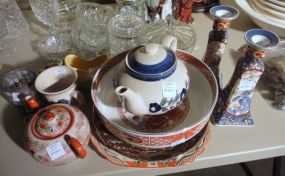  Group of Decorative Household Items Group of Decorative Household Items; two oriental candle holders, two oriental tea, three oriental plates, one oriental bowl, decorative glass candle holder and glass clog.
