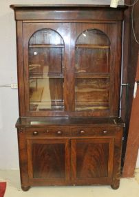  Empire Bookcase/Secretary Circa 1840 mahogany bookcase fold over secretary, two glass doors with interior shelves over two drawer, two door base supported by bun feet. (slight damage to veneer) 45"w., 19"d., 88"h.