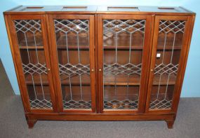 Early 1900's cherry bookcase. Unusual bookcase with four leaded glass doors and two interior shelves. One door has cracked glass; 52" w., 12" d., 40 1/2" h.