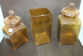 Two Amber Colored Glass Covered Jars and Amber Vase Jars 11 1/2" dia., 13 1/2" h., vase 10 1/2" h.