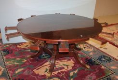 Round Mahogany Starburst Inlaid Dining Table on a Quadruple Pedestal Support with Brass Caps and Castors