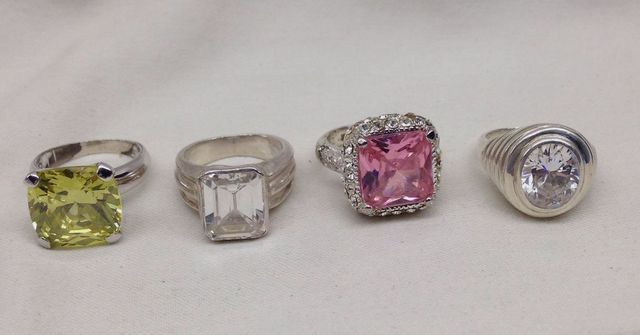 Four Stamped Sterling Silver Lady's Simulated Gemstone Rings with a Bright Polish Finish.