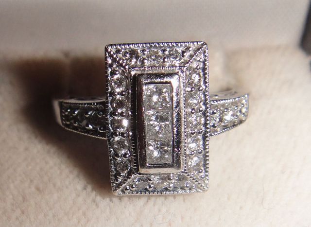 One pair stamped 14KT white gold lady's cast three diamond ring