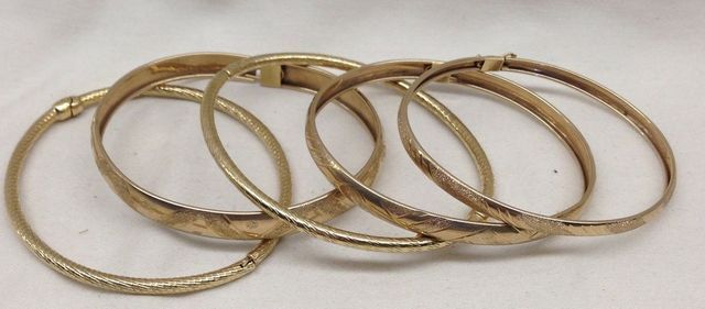 Five stamped 10KT yellow gold lady's Bangle bracelets with a varying finish