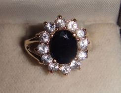 One stamped 14KT yellow gold lady's cast sapphire and aquamarine ring with a split shank with a bright polish finish. Containing: One prong set oval standard brilliant cut natural blue sapphire, measuring 8.90 x 6.85 x 3.02mm, 6% bulge factor, a