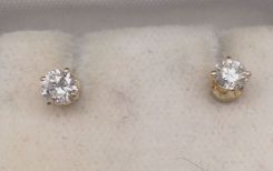 One pair stamped 14KT yellow gold lady's die struck diamond stud earrings with friction post with nut backs with a bright polish finish. Containing: Two prong set round brilliant cut diamonds, measuring 4.07-4.02 x 2.43mm (depth est.) approximat