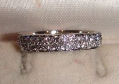 One stamped 14KT white gold lady's cast pave' diamond band with a flat shank with a bright polish finish. Containing; Sixty-eight pave' set round brilliant cut diamonds, measuring 1.60-1.40 x 0.90mm (depth est.) approximate total weight of 68 St