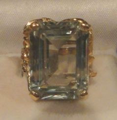 One 10-14KT yellow gold lady's cast spinel ring with a bark style shank with a bark finish with high polish accents finish. Containing: One prong set emerald standard step cut synthetic, measuring 20.08 x 15.20 x 8.40mm, 12% bulge factor, approx