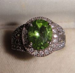 One stamped 14KT white god lady's peridot and diamond ring with a bright polish with filigree accents finish. Containing: Forty-eight pave' set round brilliant cut diamonds, measuring 2.00-1.80 x 1.14mm (depth est.) approximate total weight of 4